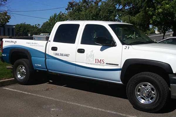 IMS branded crew-cab truck wrap in white and blue